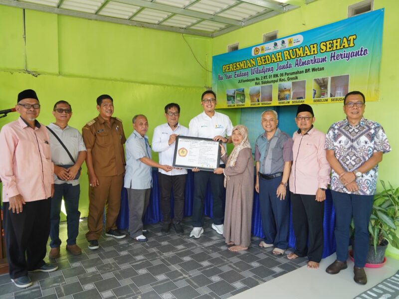 Yuni Endang Wiludjeng (berhijab) menerima pigura yang menandai serah terima rumahnya pada Senin (7/6) di Gresik setelah direnovasi melalui program Bedah Rumah Sehat yang diadakan PLN Nusantara Power berkolaborasi dengan LAZIS PLN NP dan IKPLN.