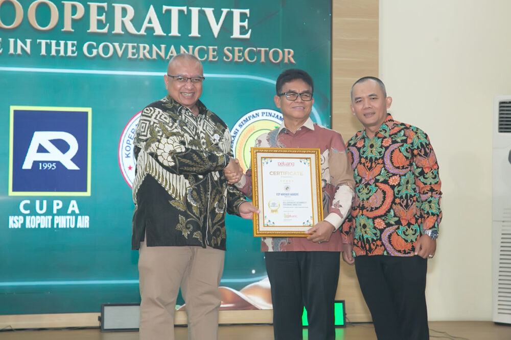 Ketua KSP Makmur Mandiri Tumbur Naibaho menerima penghargaan. Foto: Peluang