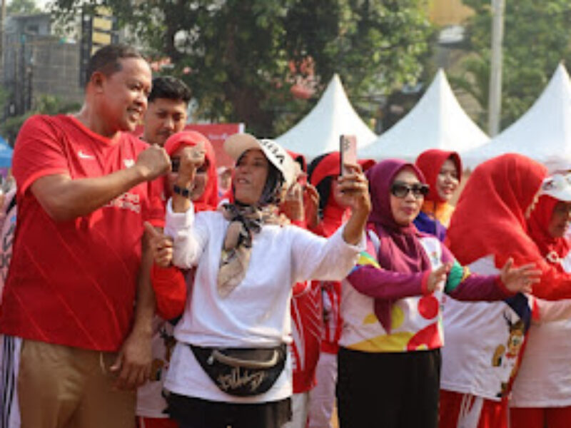 Wali Kota Bekasi Tri Adhianto bersama Ketua Komite Olahraga Masyarakat Indonesia (KORMI) Kota Bekasi Wiwiek Hargono mengikuti senam sehat bersama para lansia dan komunitas olahraga masyarakat di Lapangan Kecamatan Pondok Gede, Minggu (18/10/2026). Foto: indik.id